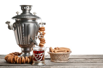 Photo of Composition with hot tea and delicious ring shaped Sushki (dry bagels) on wooden table against white background, space for text