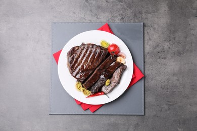 Photo of Delicious grilled beef meat on grey table, top view