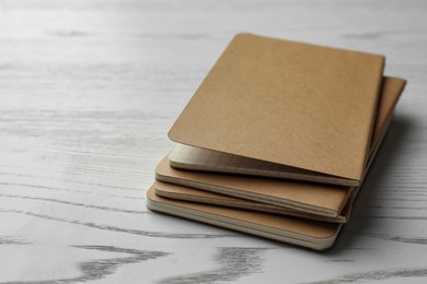 Photo of Kraft planners on white wooden table, closeup. Space for text