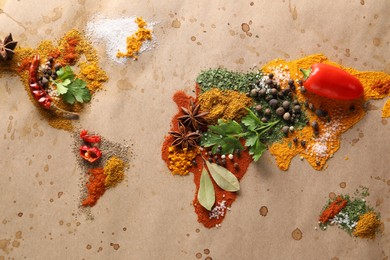 Photo of World map of different spices and products on old paper, flat lay