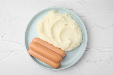 Photo of Delicious boiled sausages and mashed potato on white textured table, top view