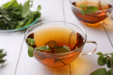 Photo of Aromatic herbal tea with mint on white wooden table