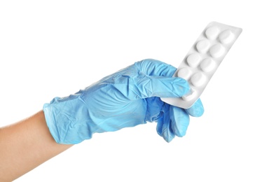 Doctor in medical glove holding pills on white background