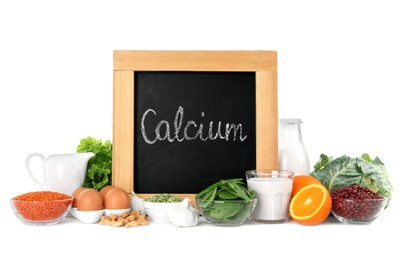 Photo of Set of natural food and chalkboard with written word Calcium on white background
