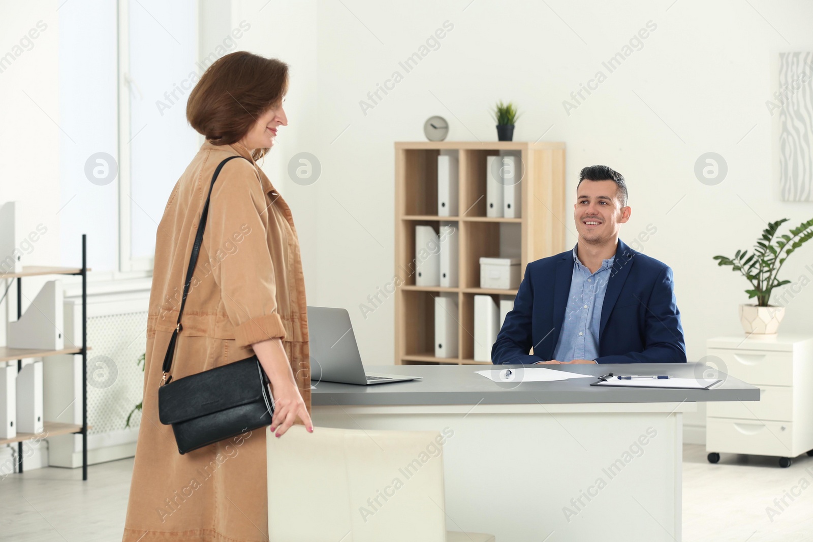 Photo of Human resources manager speaking with applicant before job interview in office