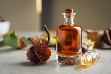 Photo of Horse chestnut and bottles of tincture on grey table