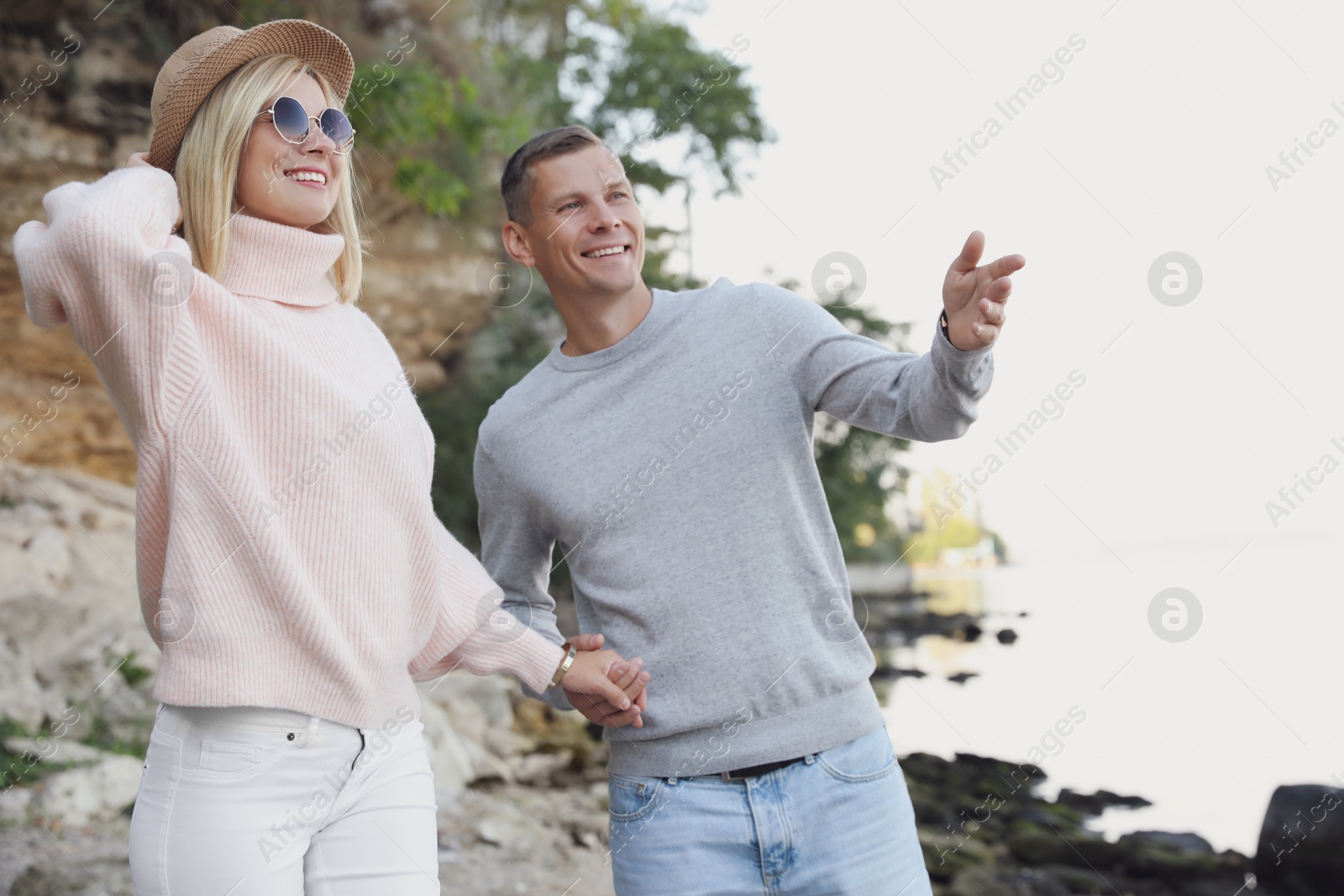 Photo of Happy couple in stylish sweaters on beach