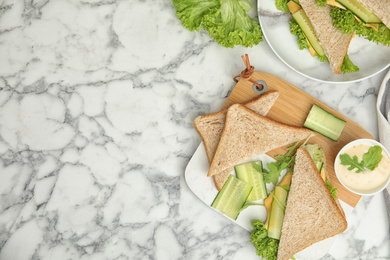 Flat lay composition with tasty sandwich and ingredients on white marble table. Space for text