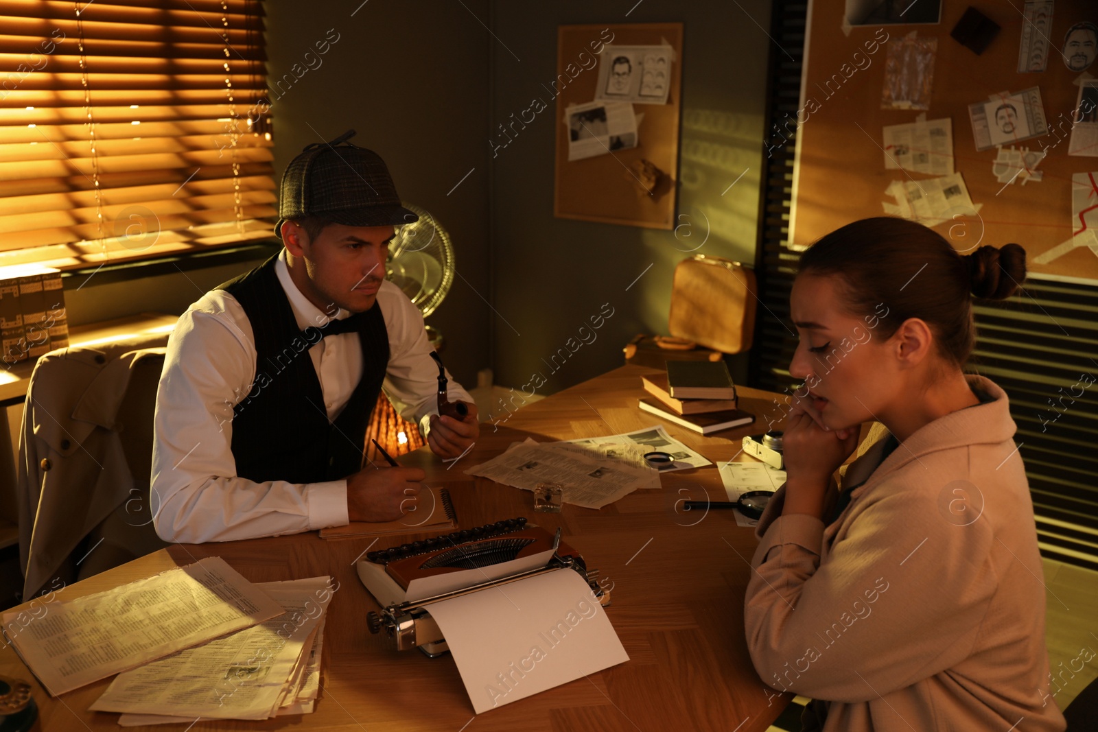 Photo of Old fashioned detective working with client in office