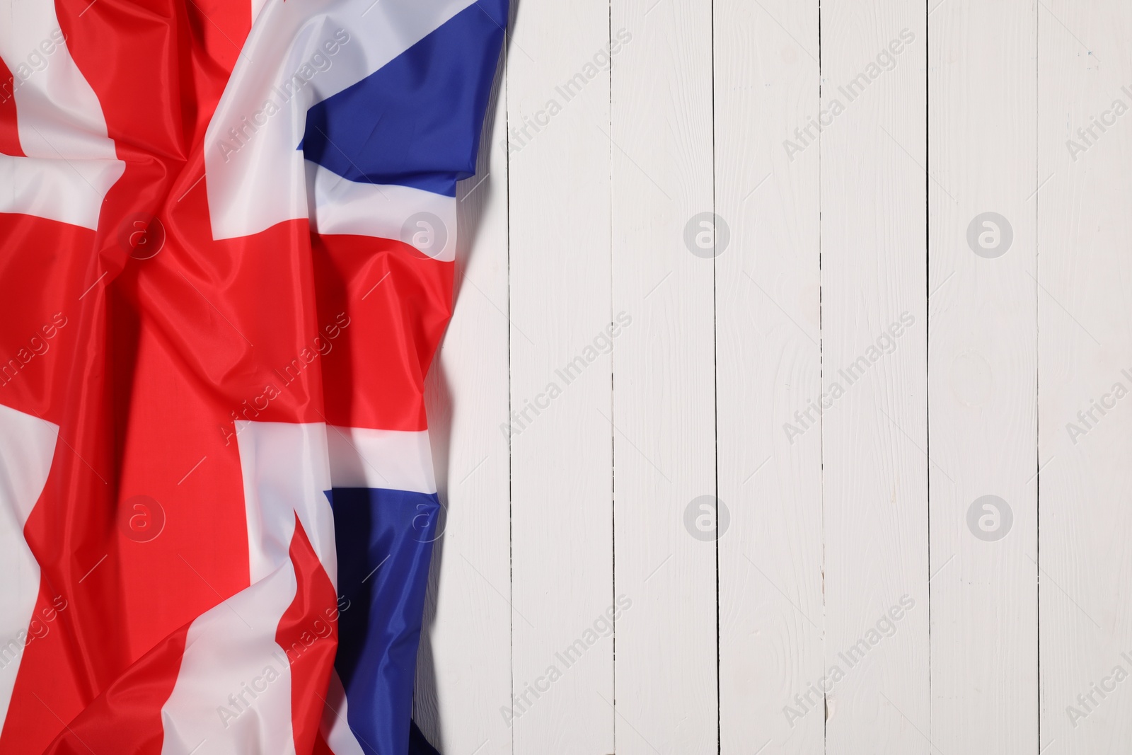 Photo of Flag of United Kingdom on white wooden background, top view. Space for text