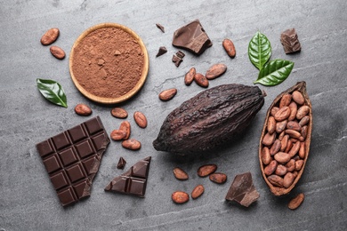 Photo of Flat lay composition with cocoa pods and chocolate on grey table