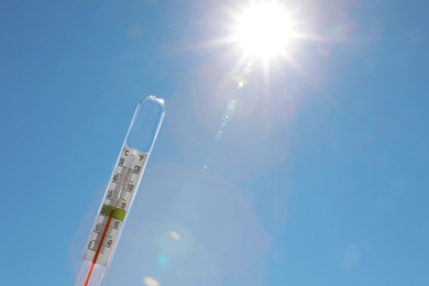 Weather thermometer against blue sky, space for text