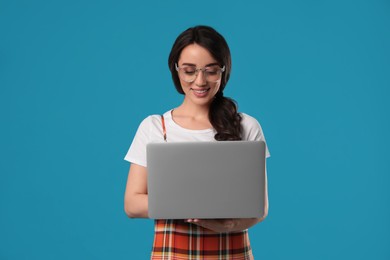 Photo of Young woman with laptop on blue background