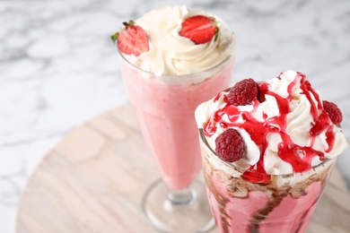 Tasty milk shakes with toppings on table