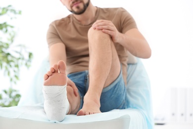 Man with broken leg in cast on couch