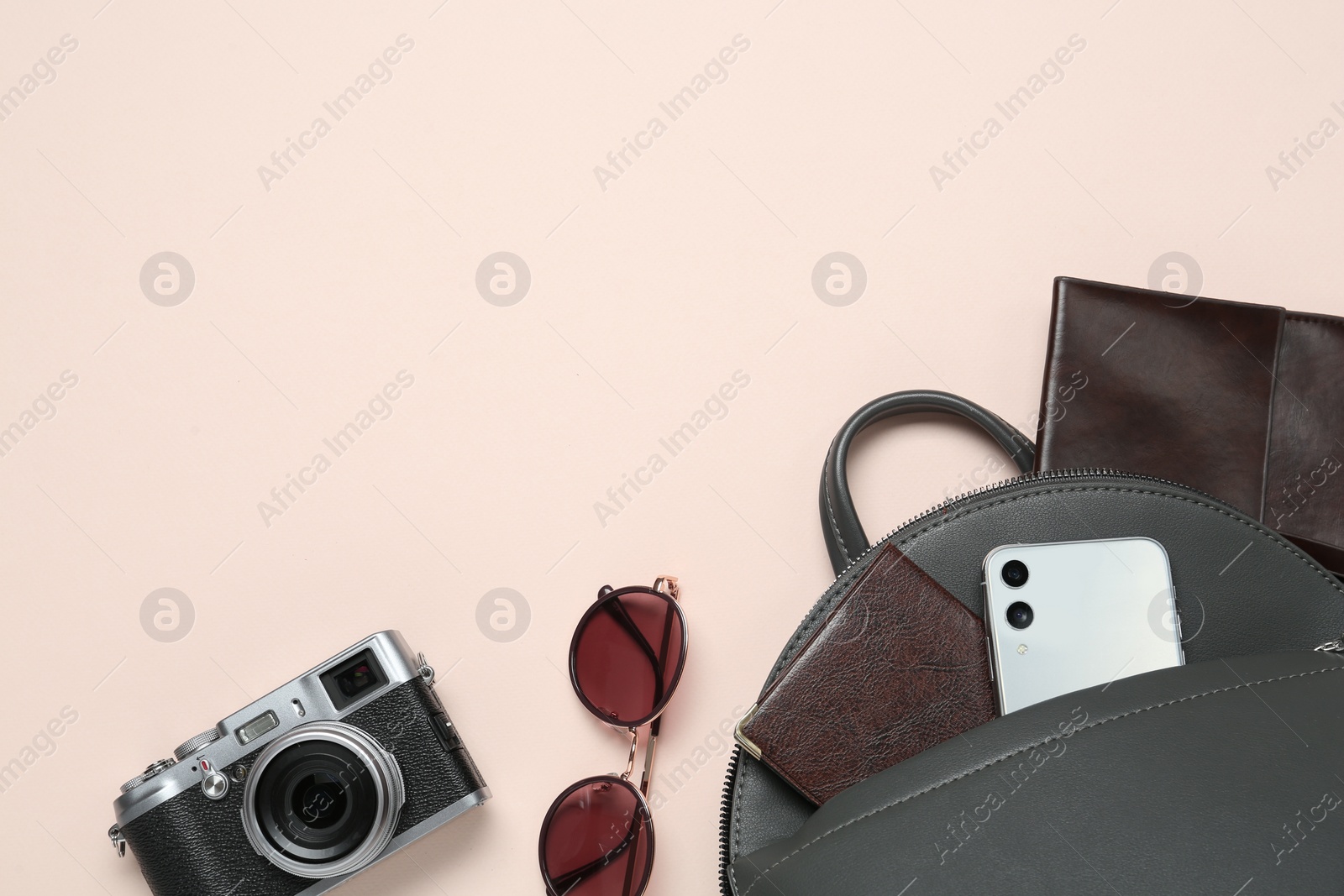 Photo of Flat lay composition with stylish backpack on beige background, space for text