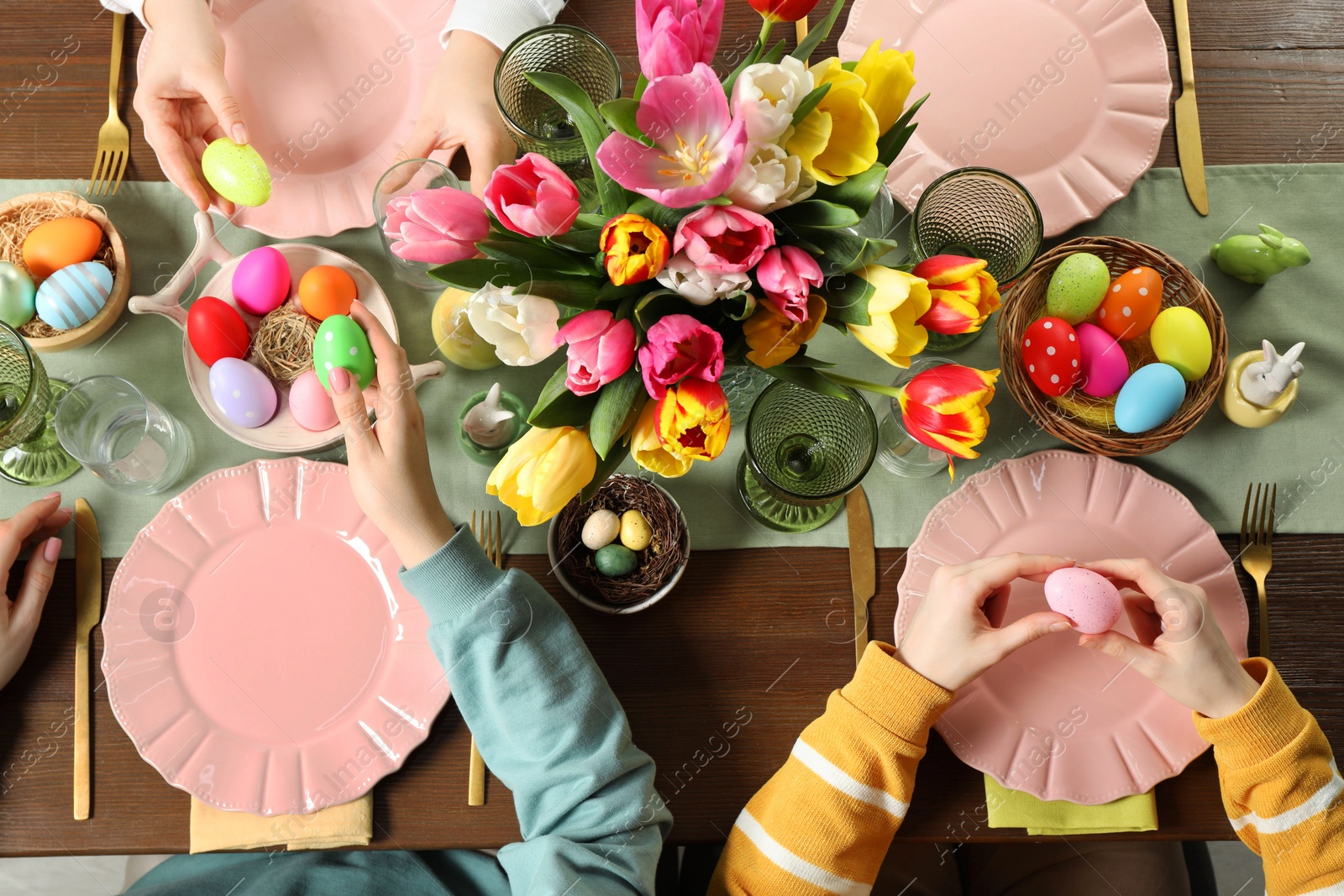 Photo of Festive table setting. Women celebrating Easter at home, top view