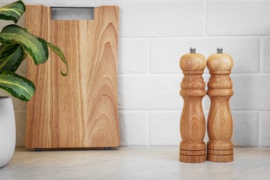 Photo of Wooden salt and pepper shakers on table, space for text