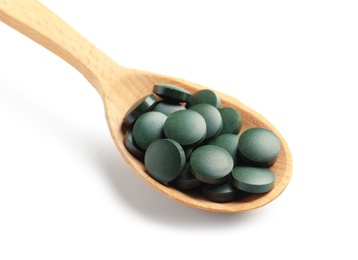 Photo of Spoon with spirulina tablets on white background