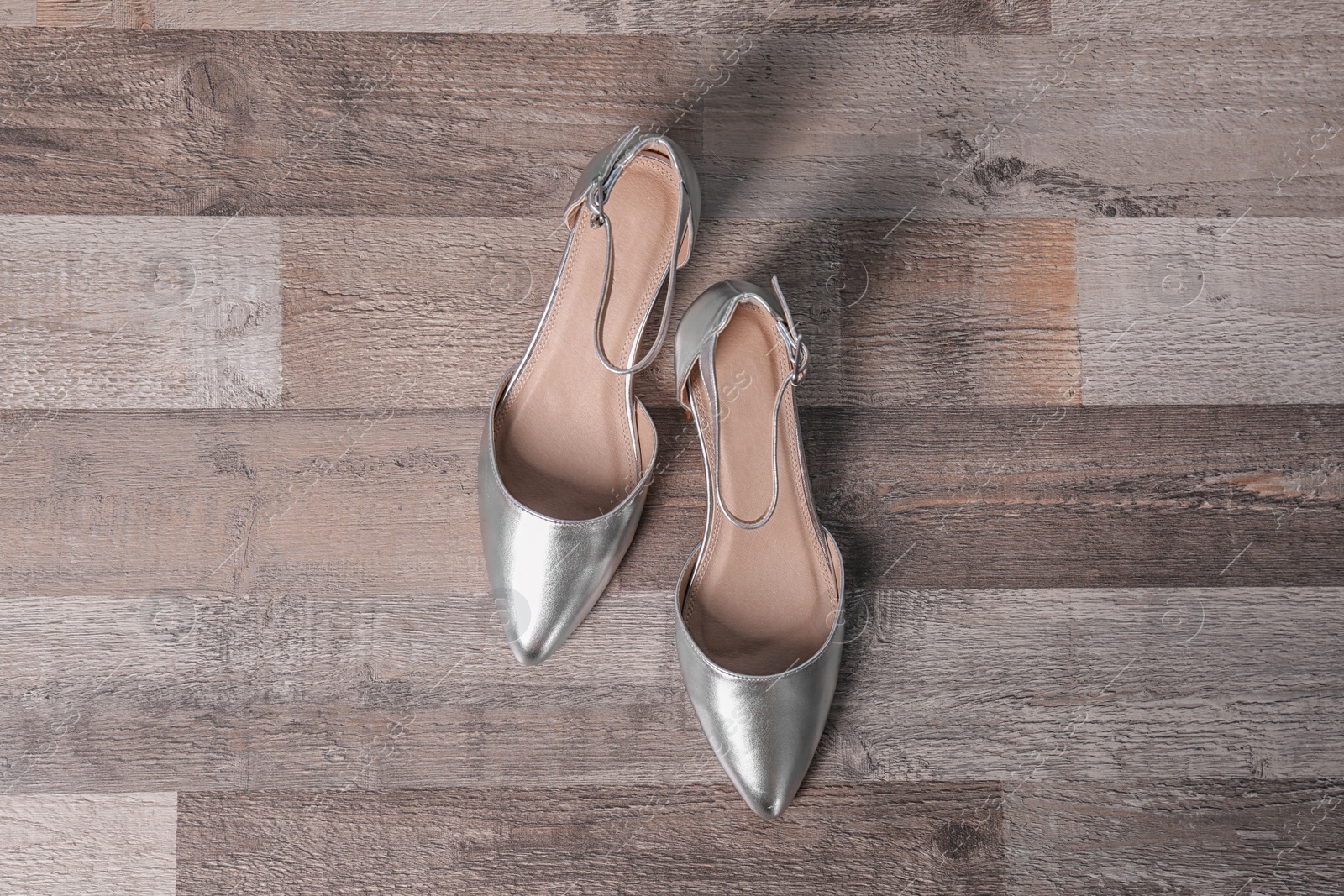 Photo of Pair of female shoes on wooden background, top view