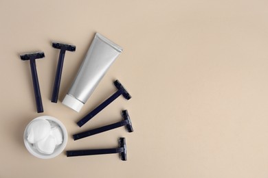 Photo of Razors, shaving foam and cream on beige background, flat lay. Space for text