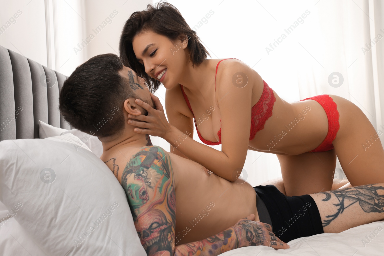 Photo of Passionate couple having sex on bed at home