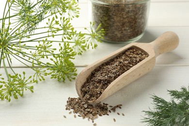 Dry seeds and fresh dill on white wooden table