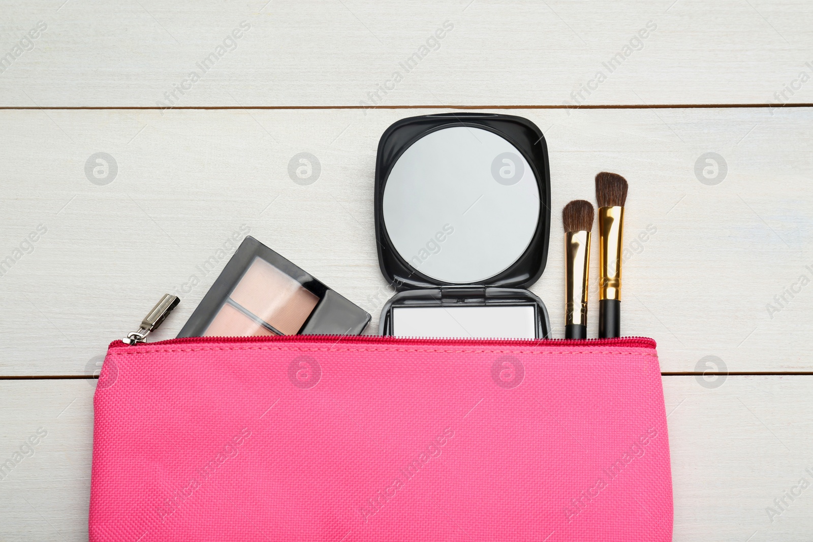 Photo of Stylish pocket mirror, cosmetic bag and makeup products on white wooden table, flat lay