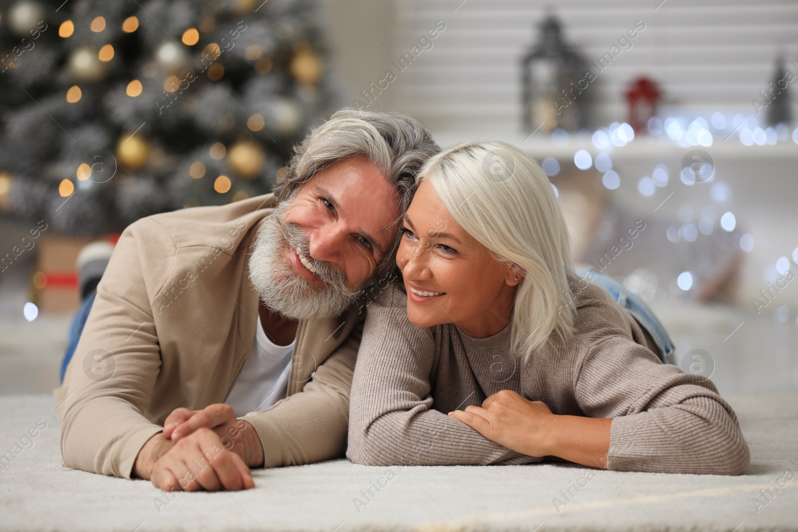 Photo of Happy couple lying on floor at home. Christmas eve