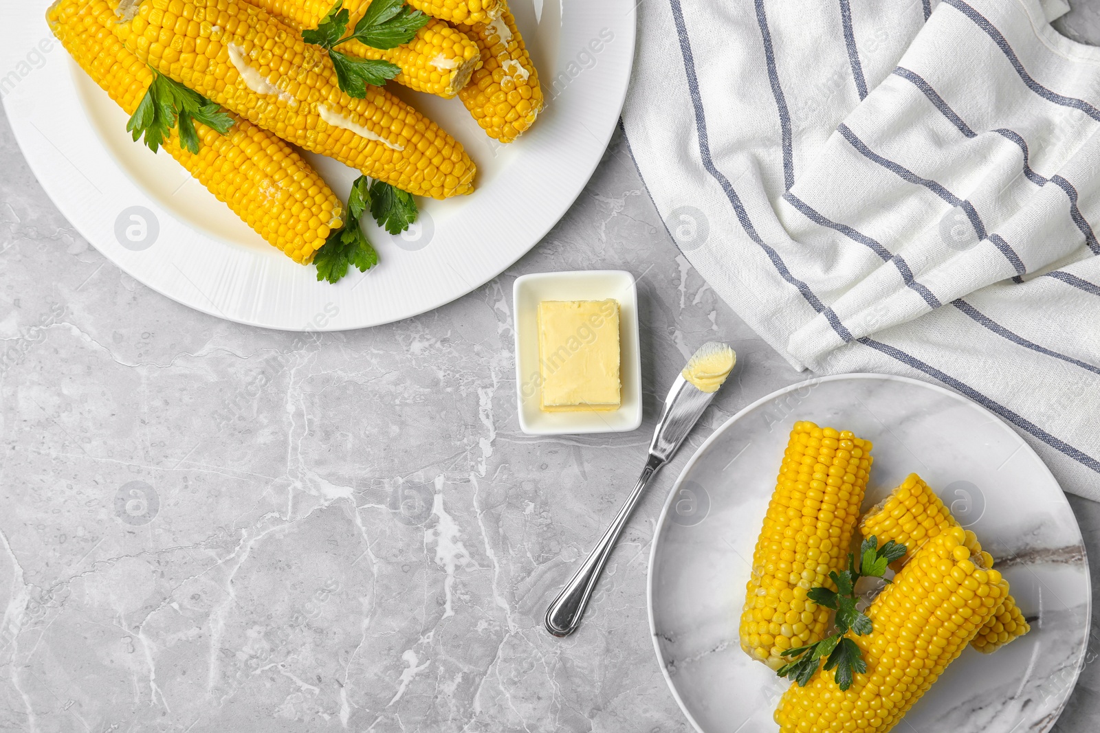 Photo of Flat lay composition of boiled corn cobs on light grey marble table. Space for text