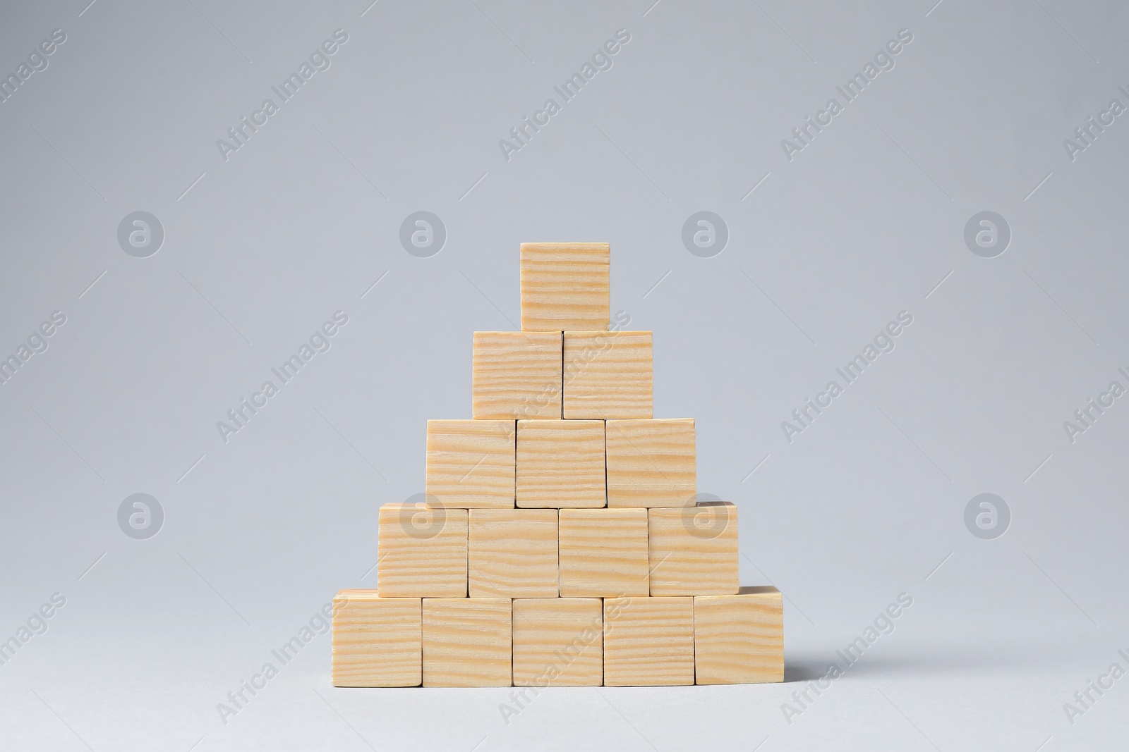 Photo of Pyramid of blank wooden cubes on light grey background