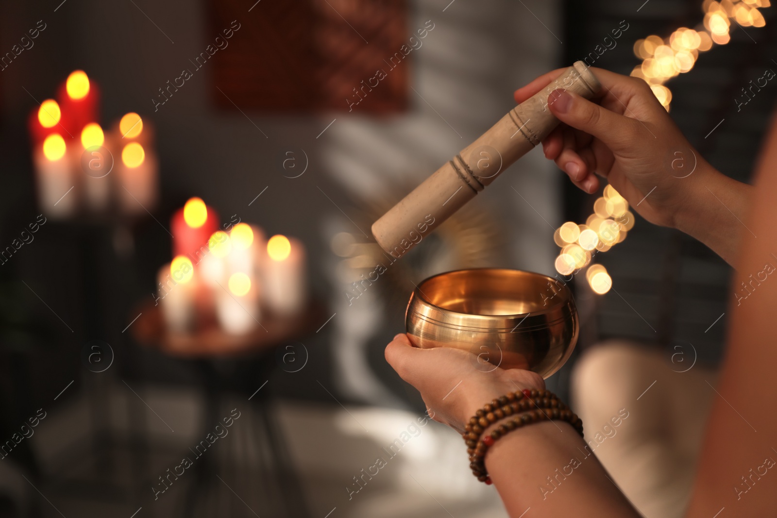 Photo of Healer using singing bowl in dark room, closeup