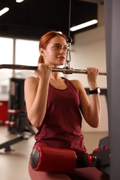 Athletic young woman training in modern gym
