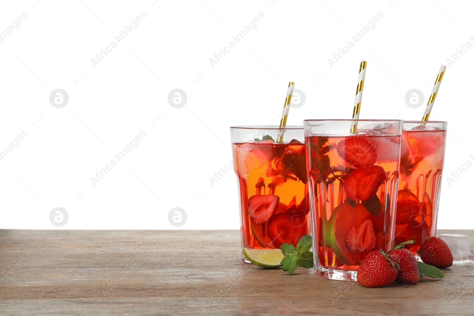 Photo of Refreshing drink with strawberry and lime on wooden table