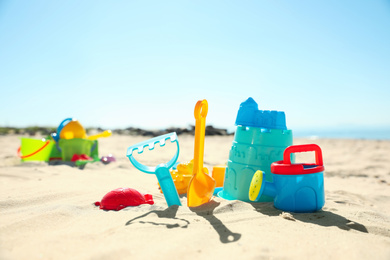 Photo of Different child plastic toys on sandy beach