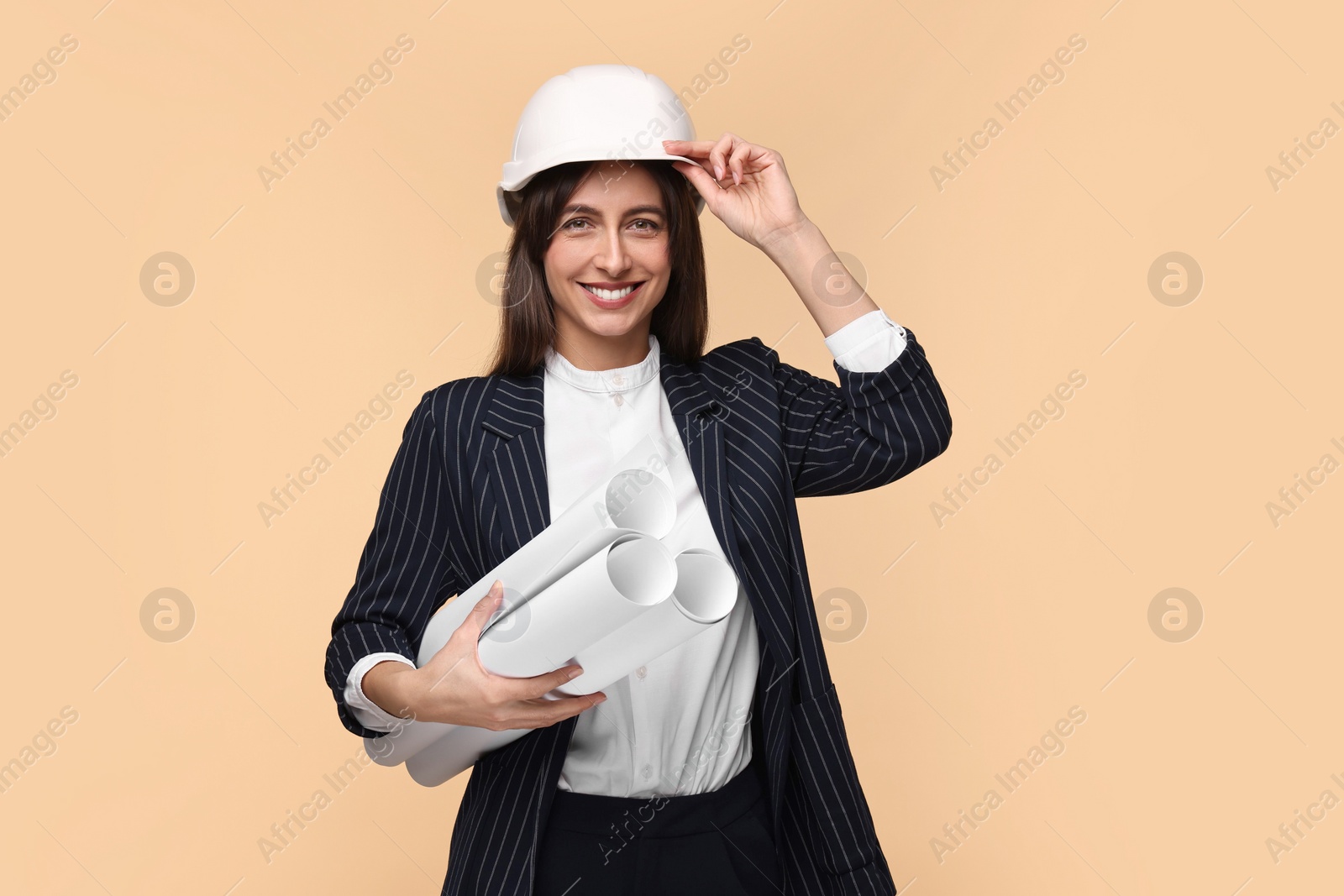 Photo of Architect in hard hat with drafts on beige background