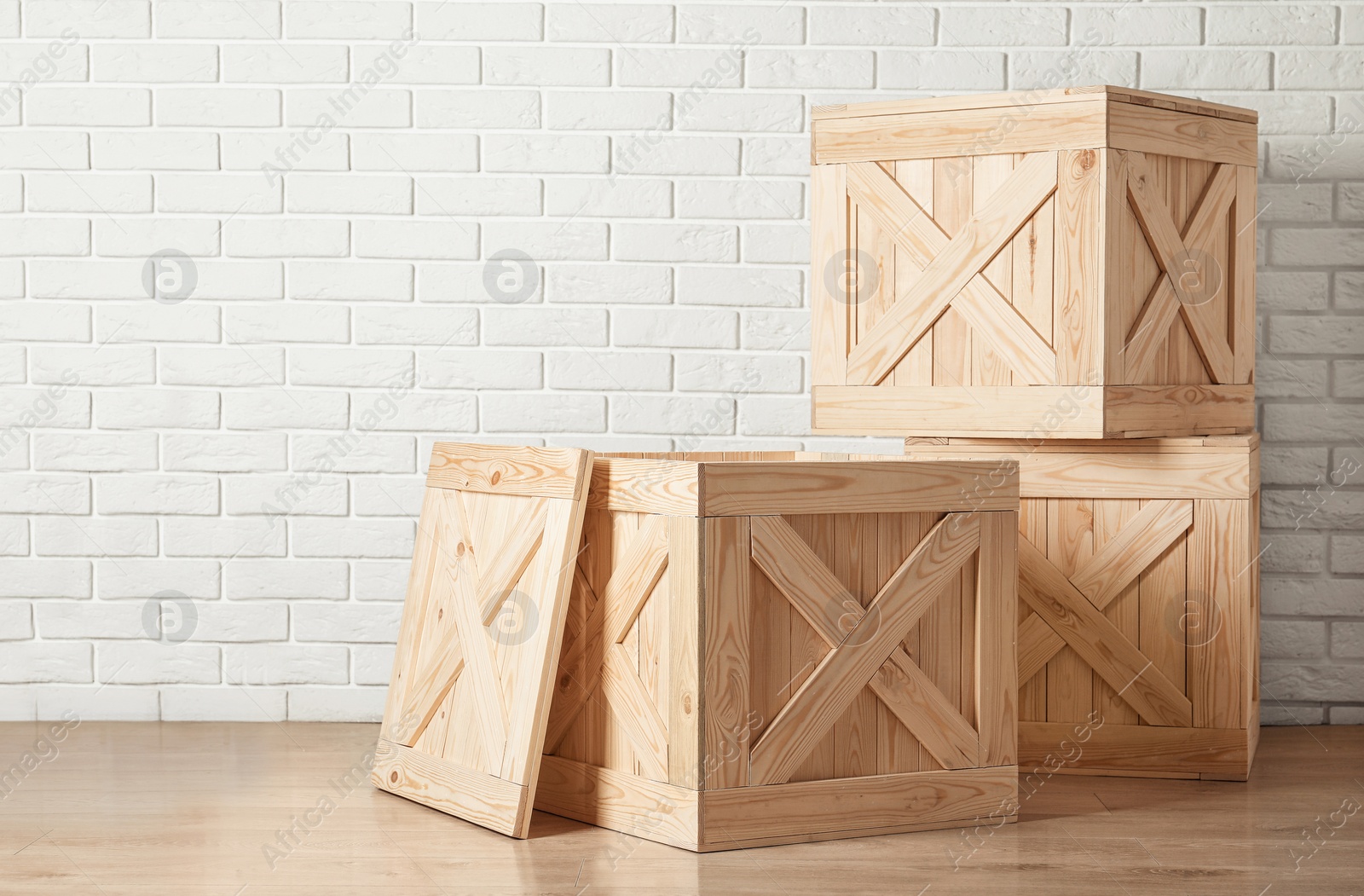 Photo of Wooden crates on floor near brick wall, space for text