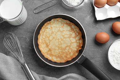 Flat lay composition with thin pancake on grey table