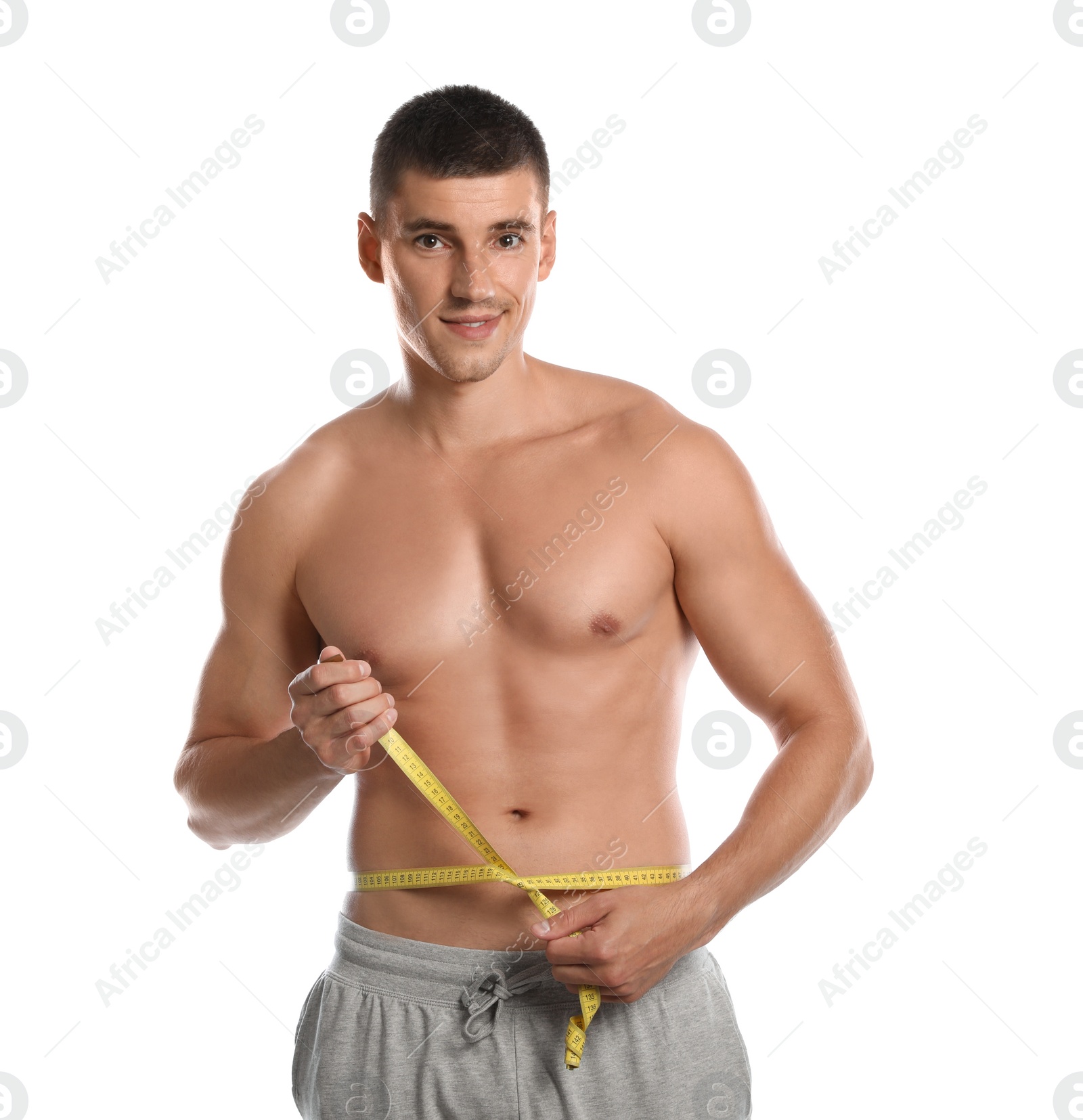 Photo of Young man with slim body using measuring tape on white background