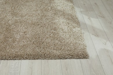 Photo of Soft beige carpet on white laminated floor indoors