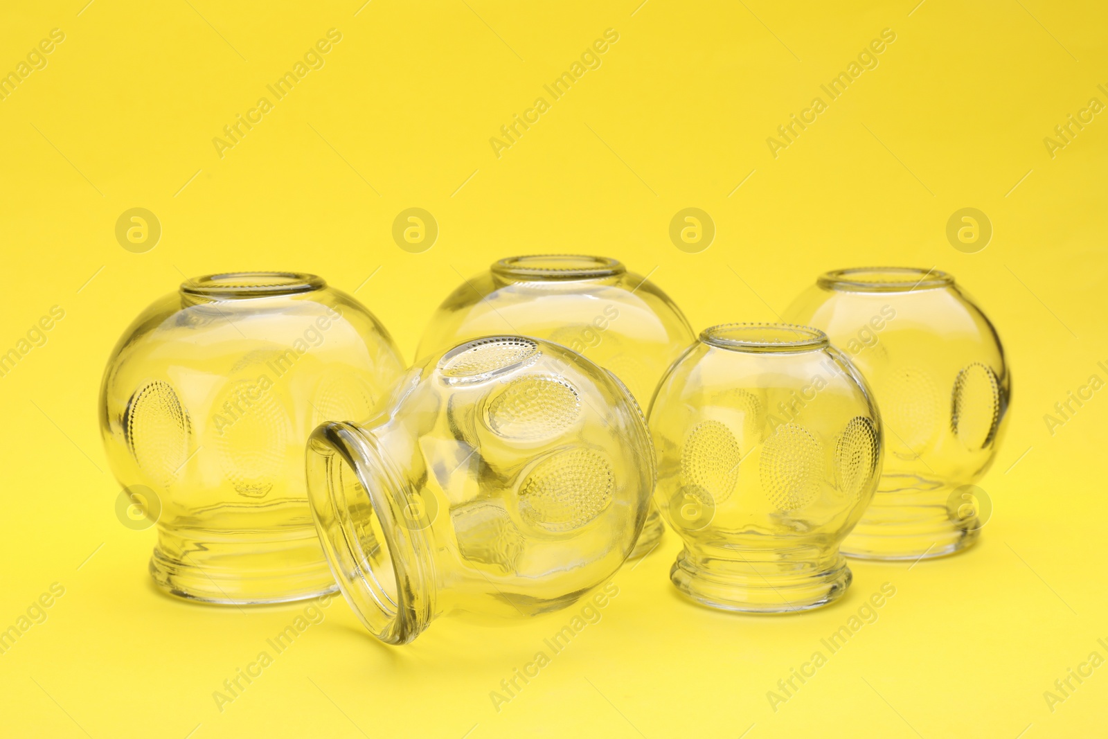 Photo of Glass cups on yellow background. Cupping therapy