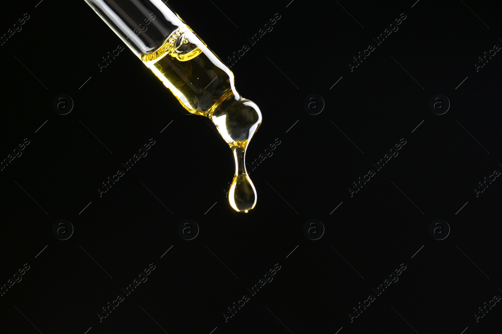 Photo of Dripping tincture from pipette on black background, closeup. Space for text