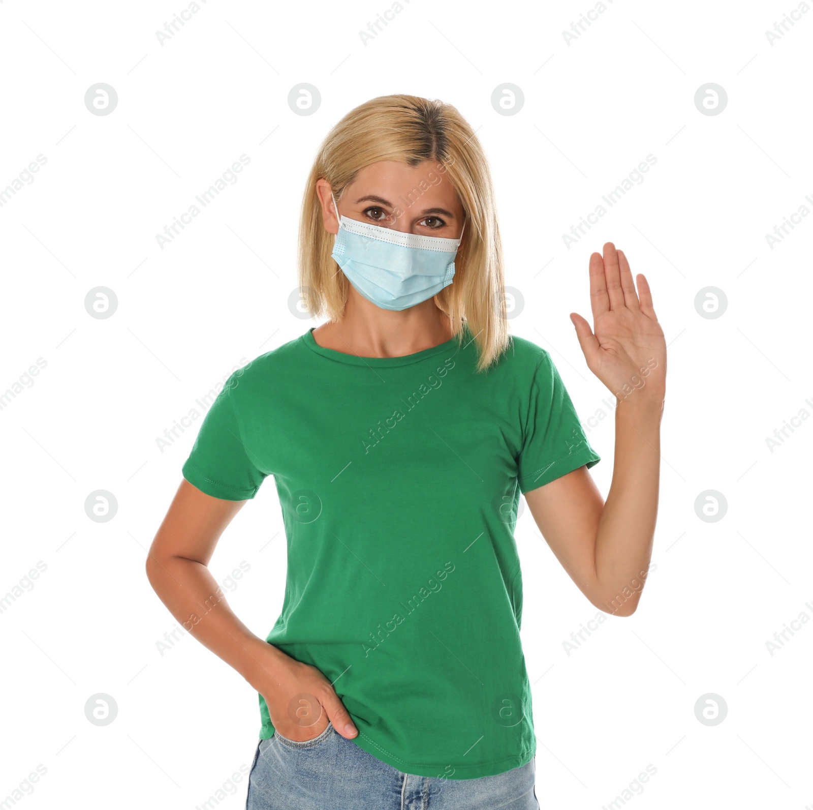 Photo of Woman in protective mask showing hello gesture on white background. Keeping social distance during coronavirus pandemic