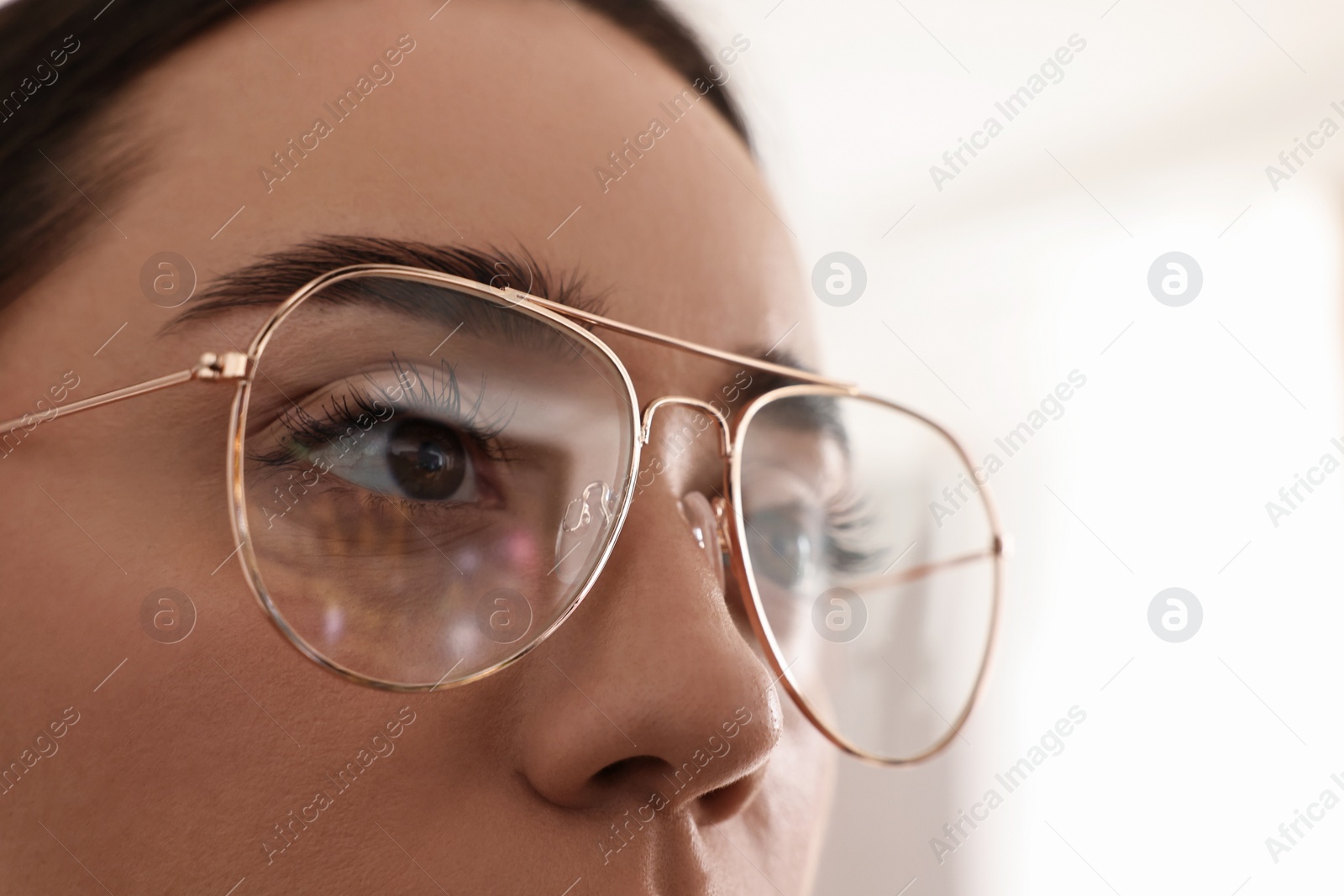 Photo of Woman wearing glasses on blurred background, closeup