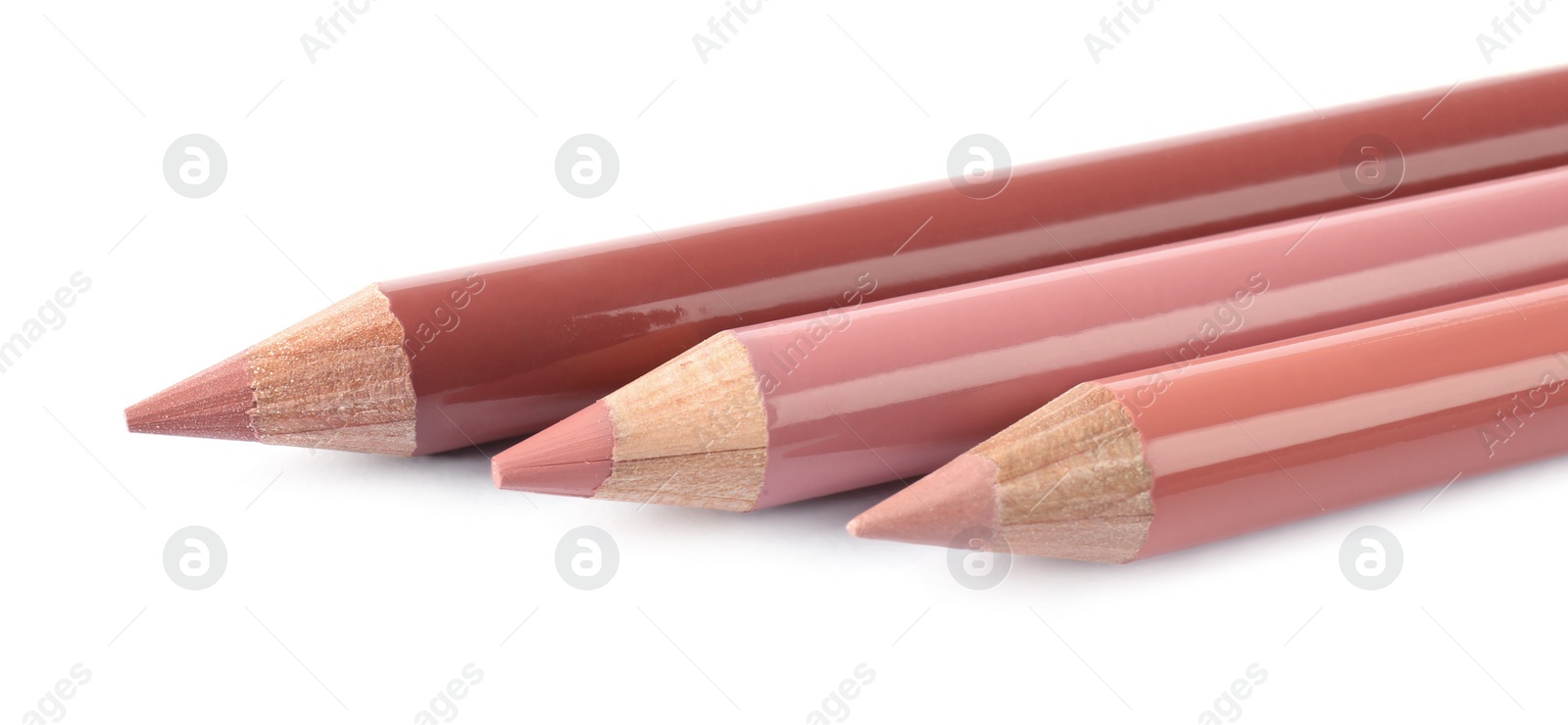 Photo of Many different lip pencils on white background, closeup. Cosmetic product