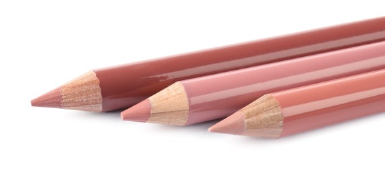 Photo of Many different lip pencils on white background, closeup. Cosmetic product