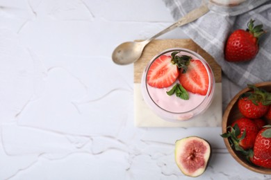 Photo of Glass with yogurt, strawberries and mint on white textured table, flat lay. Space for text