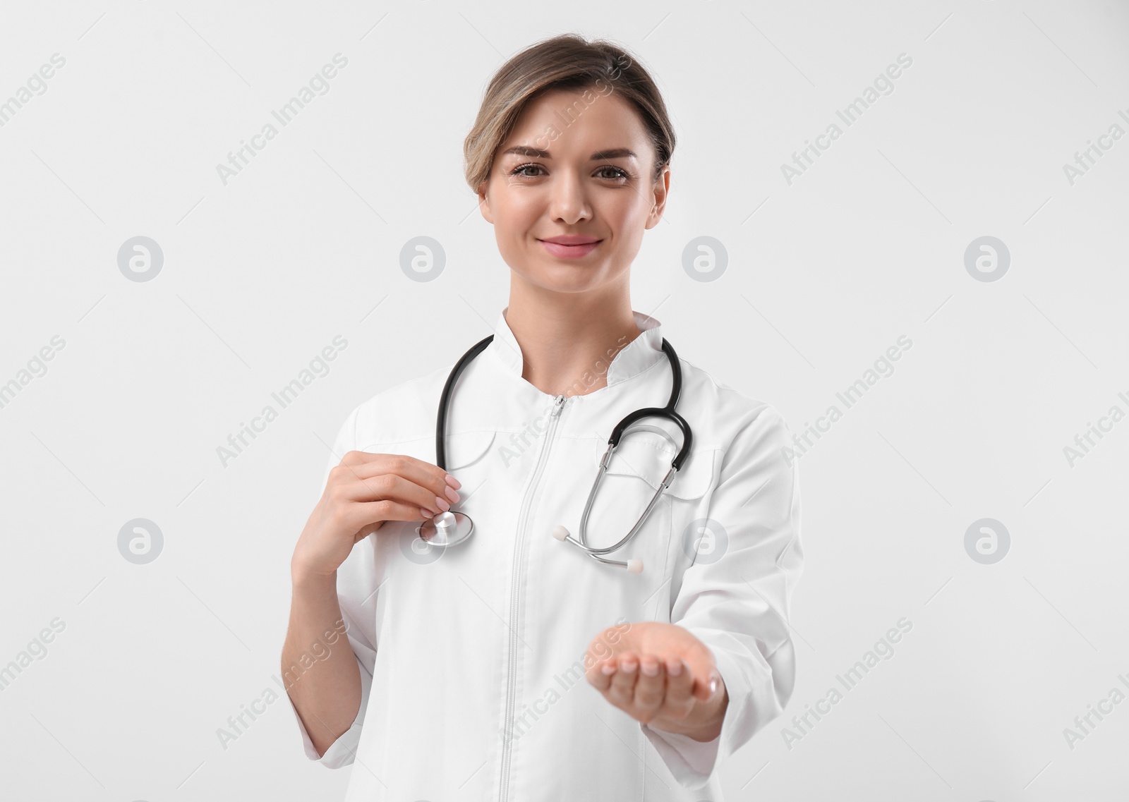 Photo of Doctor with stethoscope holding something on white background. Cardiology concept