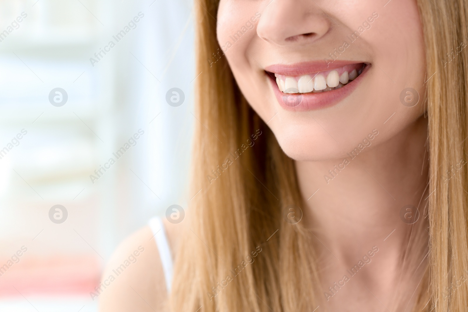 Photo of Young woman with beautiful smile indoors. Teeth whitening