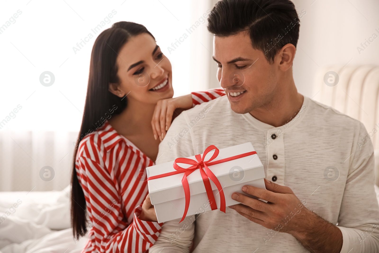 Photo of Lovely couple with gift box at home. Valentine's day celebration